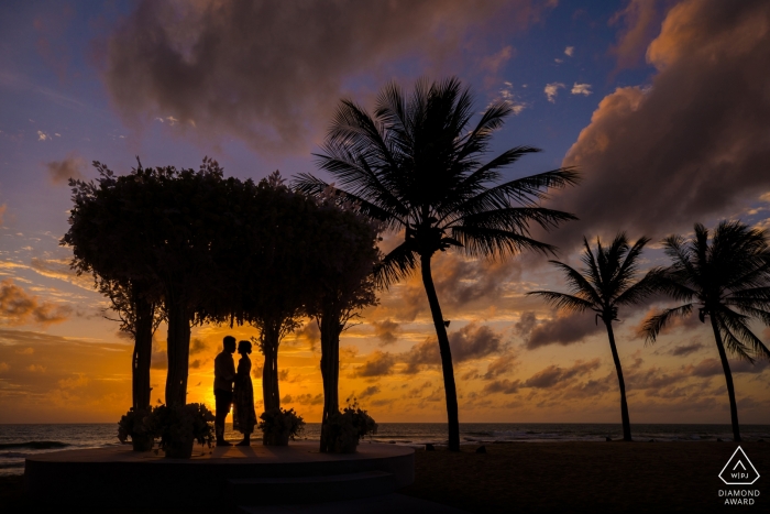 Foto door: <a href="https://www.wpja.com/photos/diamond-award-top-wedding-engagement-photographer/2260691"> Mango Gu - China Wedding Photographer </a> verlovingsshoot met een paar afgetekend bij zonsondergang met palmen | Hangzhou City fotograaf pre-huwelijkssessie
