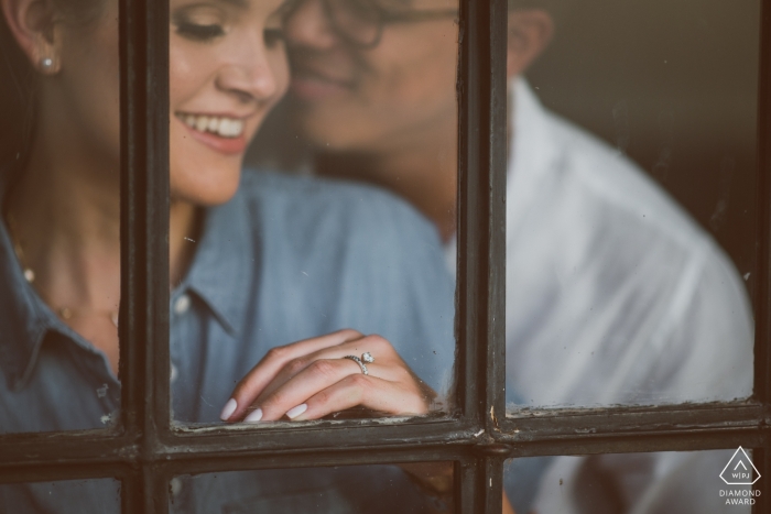 MA-Verlobungsfotos vor der Hochzeit eines Paares, aufgenommen durch ein Fenster | Boston-Porträtshooting