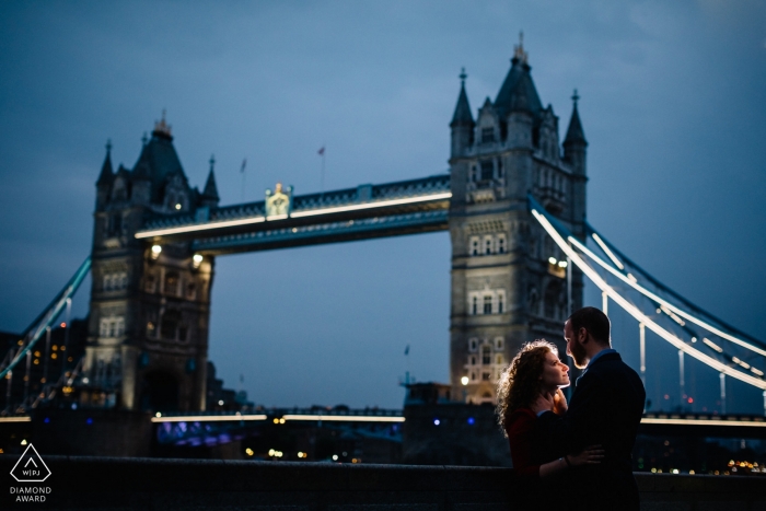 Sesión de compromiso al atardecer con una pareja en el puente de la torre