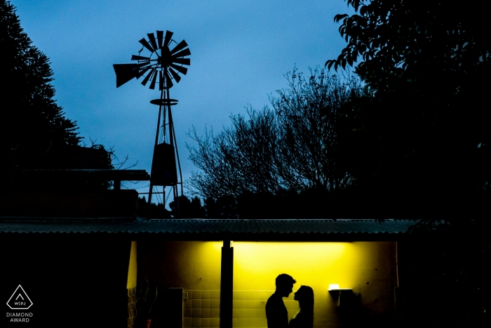 Immagini di fidanzamento illuminate di una coppia che si staglia con il mulino a vento | Sessione di spari pre-wedding del fotografo argentino