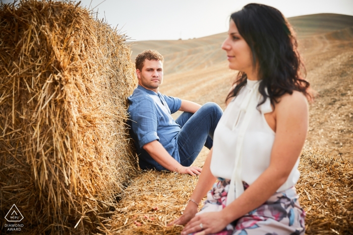 Foto door: <a href="https://www.wpja.com/photos/diamond-award-top-wedding-engagement-photographer/2312861"> David Butali - Arezzo Arezzo pre-bruiloft engagement foto's van een paar zittend op balen hooi in de velden | Toscaanse portretshoot
