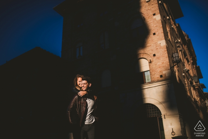 Tuscany wedding engagement portrait of a couple in the city shadows  | Siena pre-wedding photographer session