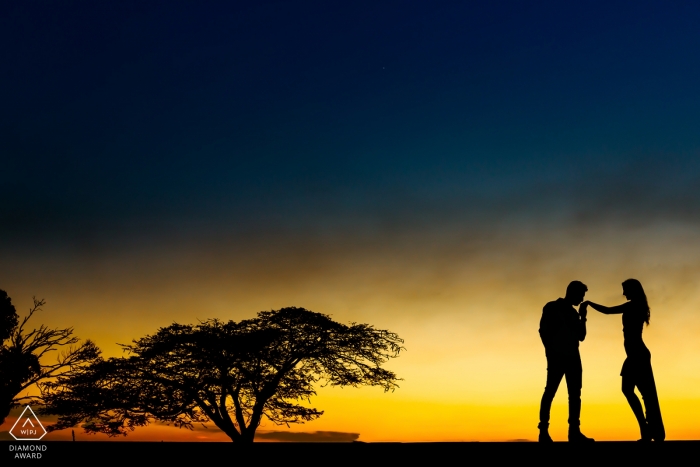 Minas Gerais Sunset Silhouette Handkuss Porträt vor der Hochzeit mit orangefarbenem bis blauem Himmel verblassen