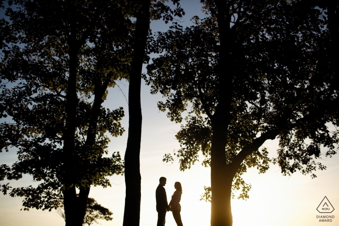 Foto por: <a href="https://www.wpja.com/photos/diamond-award-top-wedding-engagement-photographer/2291031"> Kevin Trimmer - Providence Rhode Island Fotos de compromiso de una pareja recortada entre grandes árboles | Sesión de fotos antes de la boda del fotógrafo de Rhode Island