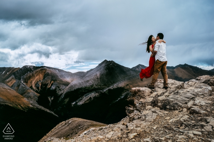 Foto di fidanzamento pre-matrimonio in cima alla montagna del Canada di una coppia al vento | Servizio fotografico dell'Alberta