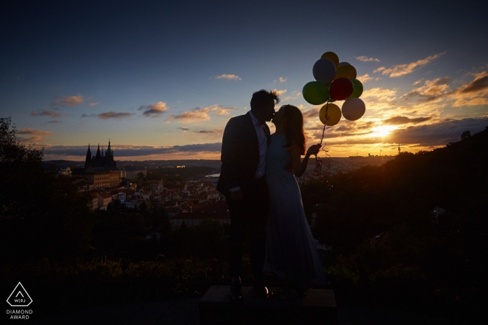 A sunrise Engagement photo session overlooking Prague for this couple holding balloons 