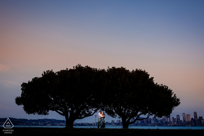 Photos de fiançailles avant mariage du Colorado d'un couple avec deux grands arbres au crépuscule | séance de photographie de couple