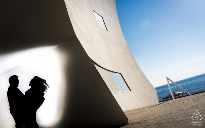 Spain engagement pictures of a couple silhouetted with buildings and water  | Murcia photographer pre-wedding photo shoot session