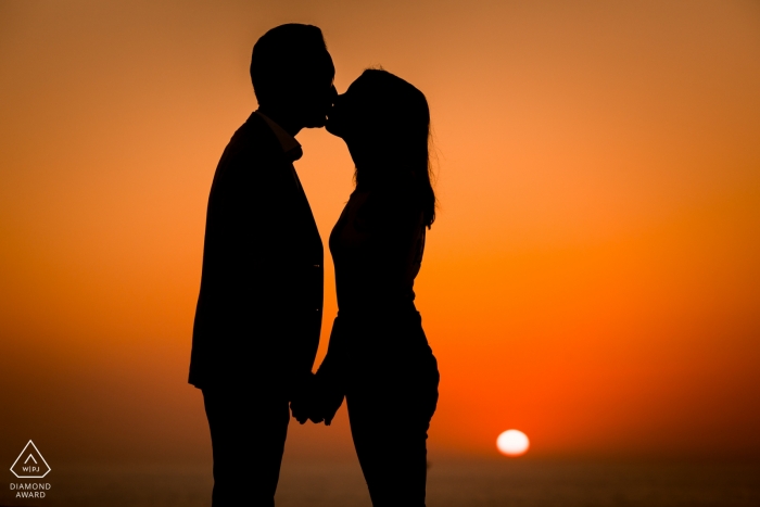 Photos de fiançailles en France d'un couple se découpant avec un soleil bas et un ciel orange | Séance photo pré-mariage avec un photographe parisien