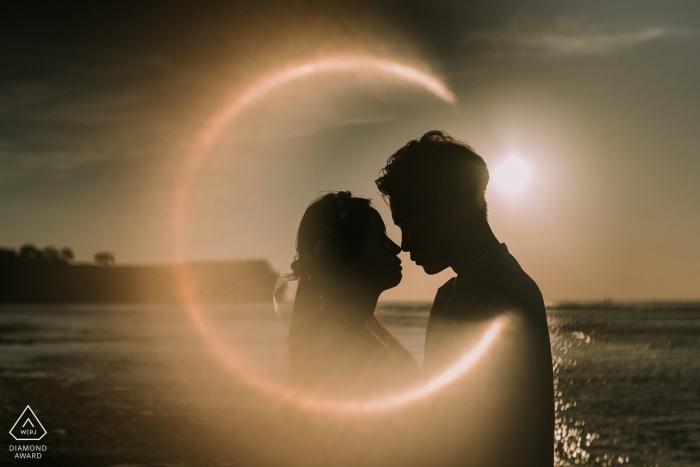 Foto: <a href="https://www.wpja.com/photos/diamond-award-top-wedding-engagement-photographer/2320106"> MangKhris Santika - Gianyar Bali Indonesien Engagement Bilder eines Paares am Meer mit Sonneneruptionen | Bali-Fotografenvorhochzeitssitzung für Porträts