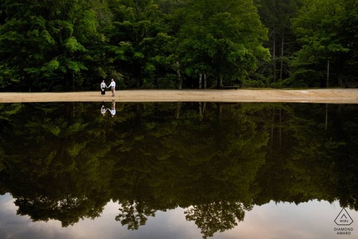 Foto por: <a href="https://www.wpja.com/photos/diamond-award-top-wedding-engagement-photographer/2323751"> Kevin Trimmer - Providence Rhode Island Imágenes de compromiso a orillas del lago de una pareja reflejada en el agua | Fotógrafo de RI sesión previa a la boda para retratos.