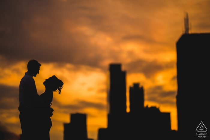 Night engagement pictures of a couple silhouetted before the city buildings  | DC photographer pre-wedding photo shoot session