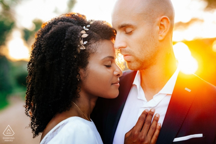 Hérault engagement photos of a couple embraced in sun flares | Occitanie photographer pre-wedding portrait session