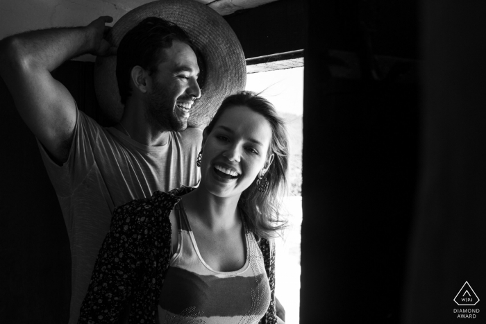 black and white pre-wedding engagement pictures of a couple in a window | Rio de Janeiro portrait shoot