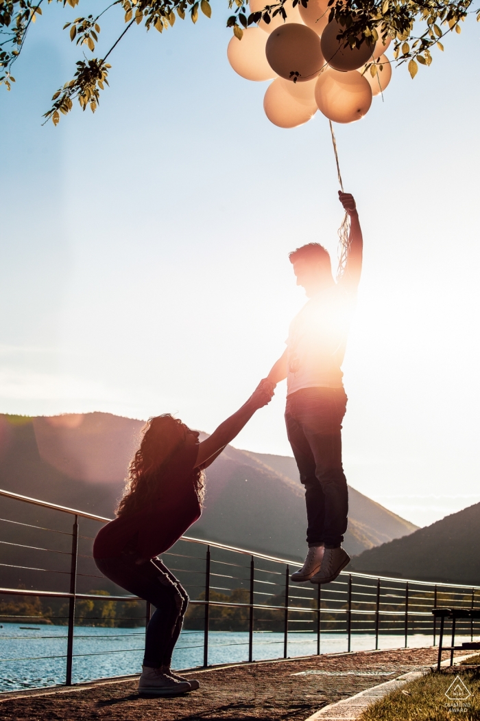 拉齊奧婚禮攝影師在水邊拍攝的一對情侶和氣球的訂婚肖像| 羅馬婚紗照