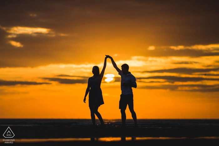 Dancing UK engagement pictures of a couple silhouetted at the beach | Northamptonshire photographer pre-wedding photo shoot session