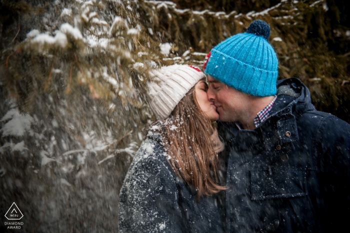 Photo by: <a href="https://www.wpja.com/photos/diamond-award-top-wedding-engagement-photographer/2368741">Cedric Derbaise - Bury Engaged couple kissing in the snow covered trees | Séance engagement photo session - France
