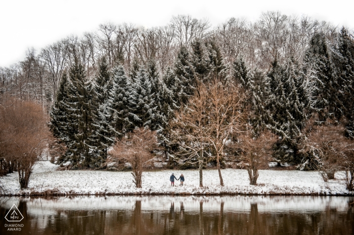 Verlobtes Paar spaziert im Schnee mit Bäumen und Bergen | Séance-Verlobungsfotografie – Frankreich