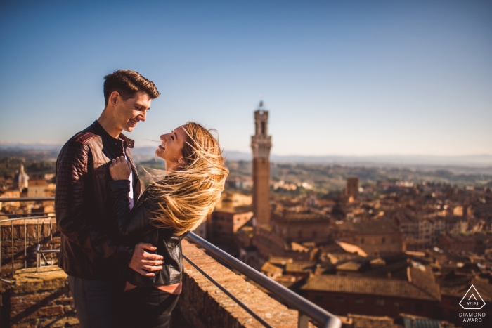 Sesión de retratos de compromiso en Siena con la ciudad como fondo.