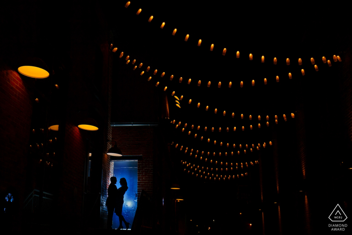 Una pareja de Colorado comparte un momento juntos en The Dairy Block en el centro de Denver durante su sesión de fotos de compromiso.