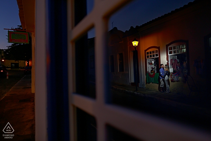 Engagement Portrait shot through glass windows in Goias