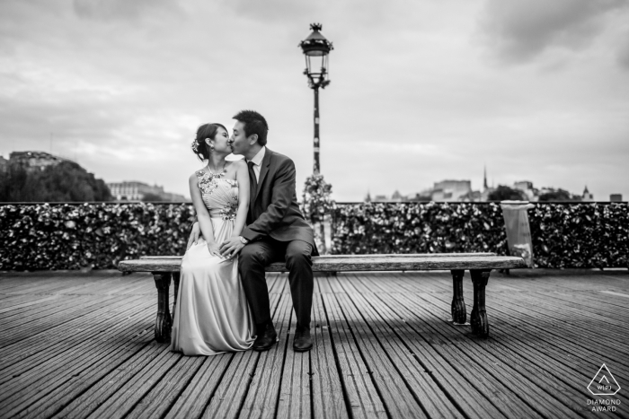 A Paris, France couple sits on a simple bench, surrounded by boardwalk lines in BW