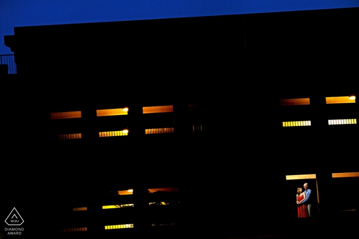 The Illinois engaged couple tenderly embraced at dusk near a parking garage tower