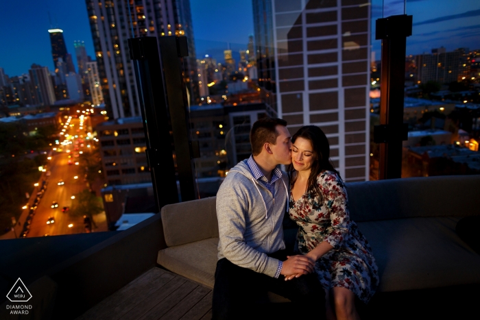 A night life loving Illinois engaged couple embraced atop a rooftop