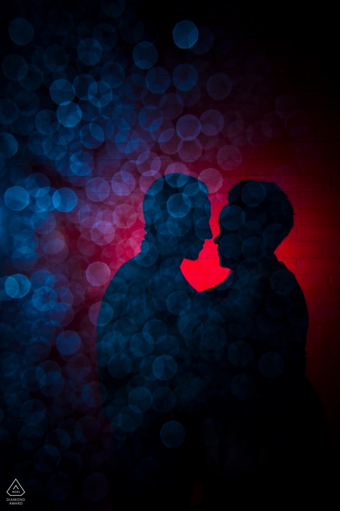 The Boulder couple standing amidst a blue bokeh scene in Colorado