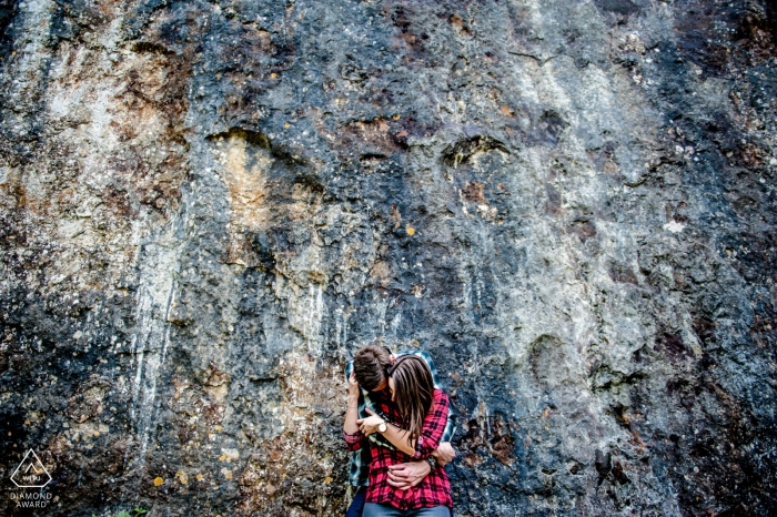 This Oise couple in a warm embrace of plaid flannel shirts below a rock wall