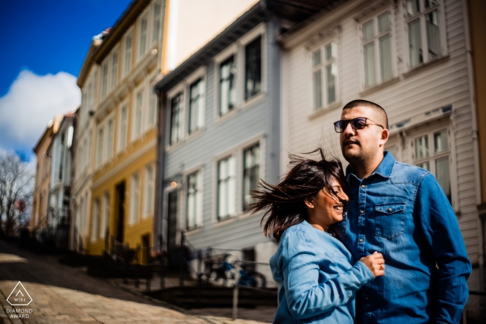 Una pareja comprometida de los Emiratos Árabes Unidos con destino a la aldea en ropa azul a juego con el cielo azul y el viento