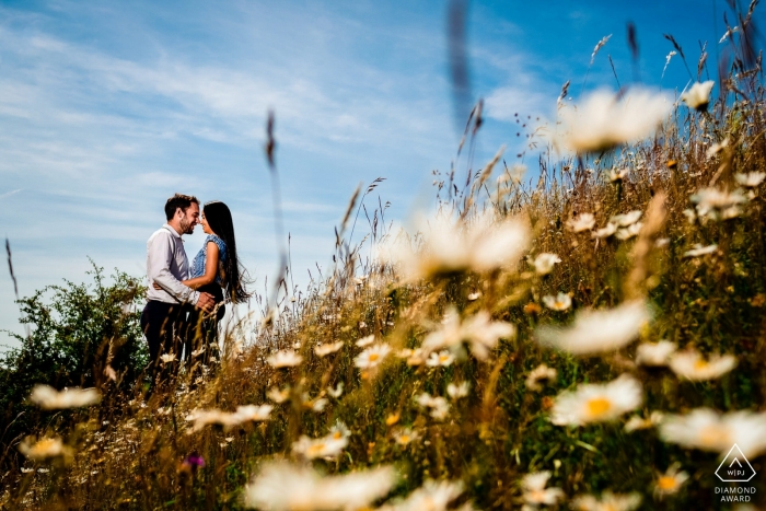 Una pareja de novios amantes del sol en París está rodeada de brillantes flores blancas y amarillas