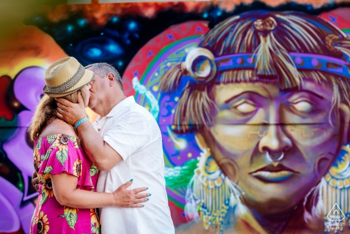 An urban Quintana Roo couple kiss each other near street art murals