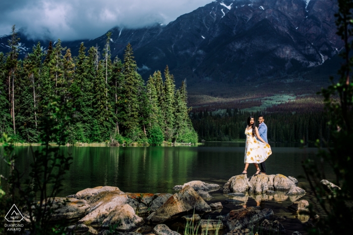 Un jeune couple albertain est perché sur l'affleurement de rochers au bord de l'eau