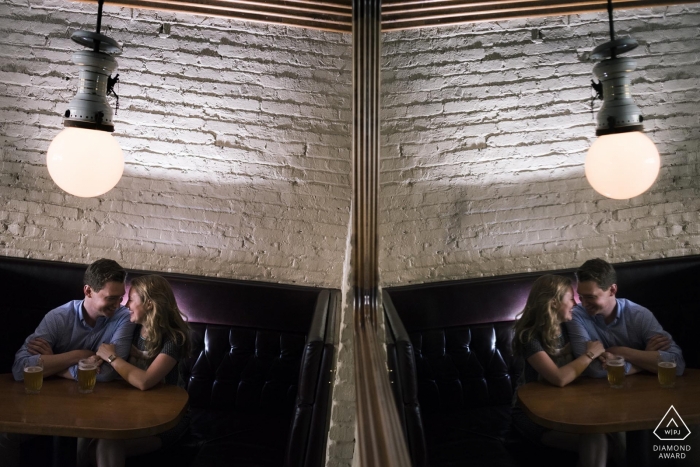 An Illinois couple sitting at restaurant table with white brick wall behind