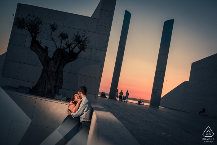 Pareja comprometida de Lisboa al atardecer con una luz cálida en sus rostros