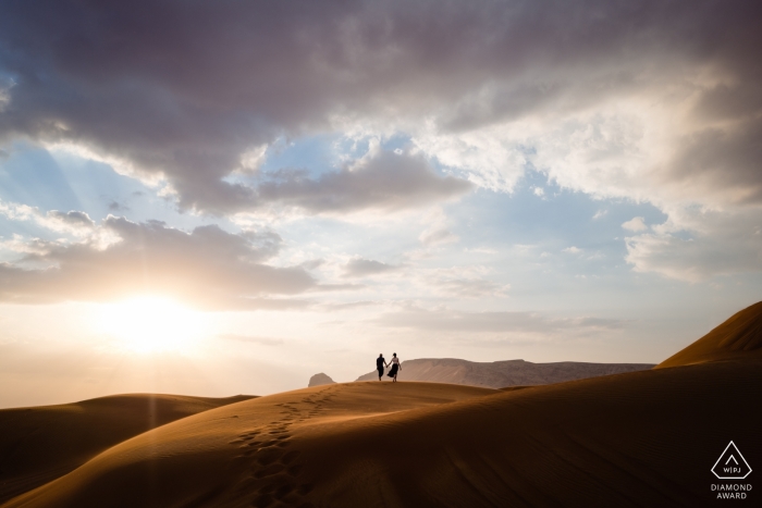 Foto di fidanzamento nel deserto di Dubai UAE per una coppia da sola su dolci colline di sabbia