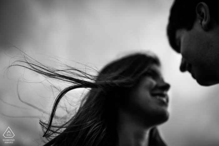 A Madrid couple poses in the wind for outdoor BW engagement portrait