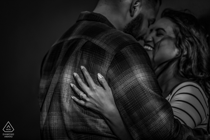 California couple embracing in the dark tones of a BW creative engagement session