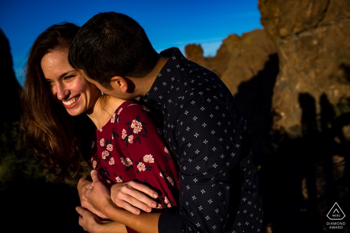 The Arizona engaged couple embraces as their shadows are cast onto the rocks 