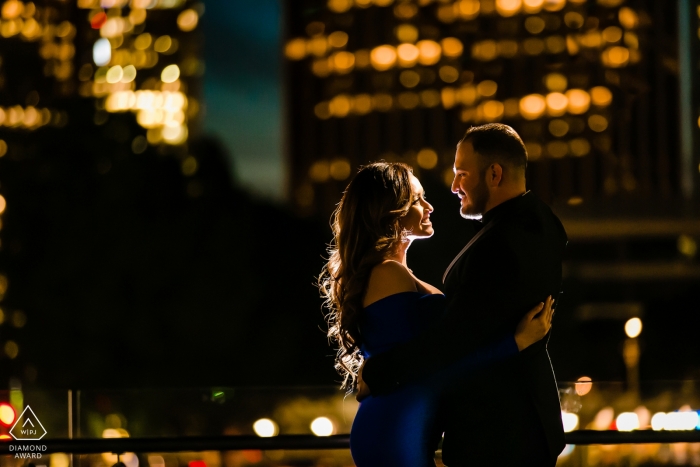 Una pareja de California frente a un deslumbrante telón de fondo de edificios iluminados