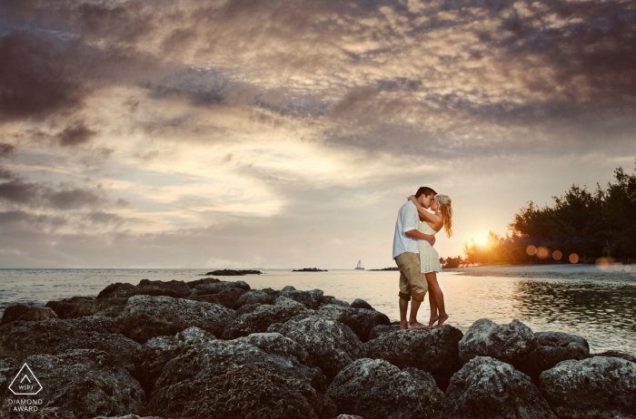 A Florida couple embraces by the water at sunset for a pre wedding photo session