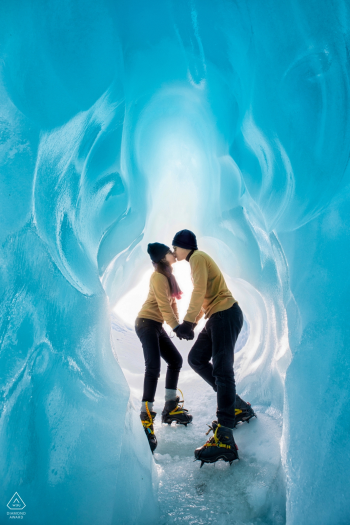 An ice hiking Hangzhou City engaged couple kiss in their matching yellow and black ice climbing gear