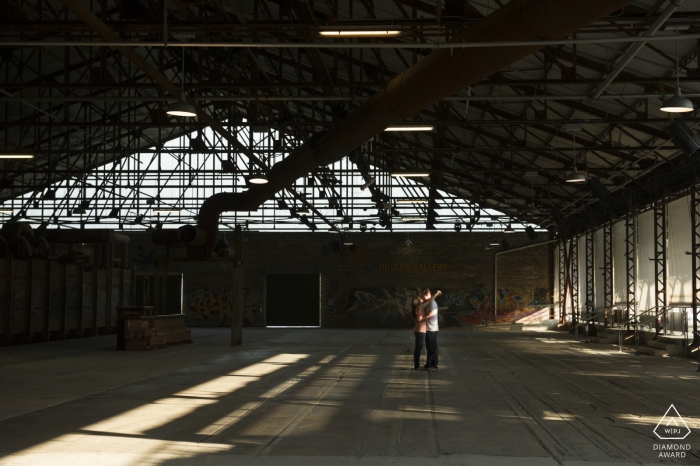 Ontario, Canada séance de portrait de couple montrant la juxtaposition de l'amour contre l'abandon dans un bâtiment industriel rustique