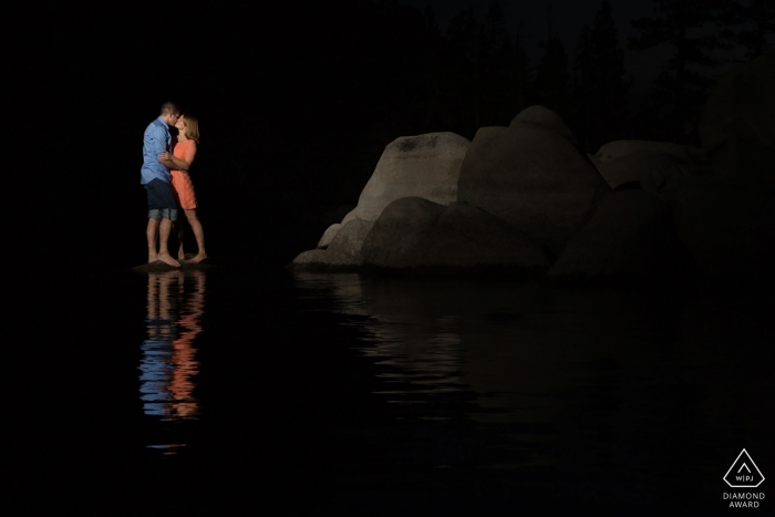 A California couple is pictured by water against a dark boulder