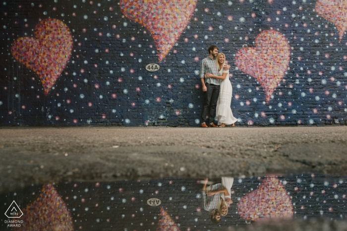 Bride to be with her man by hearts painted on a London urban wall