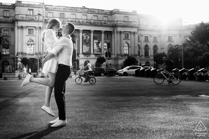 București fotografía previa a la boda de una pareja abrazándose a la luz del sol junto a un edificio