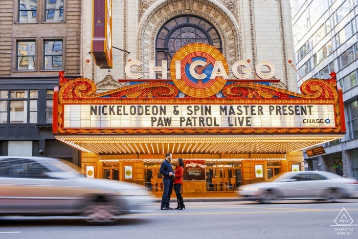 An urban Illinois couple pose in the middle of the street near the marquee