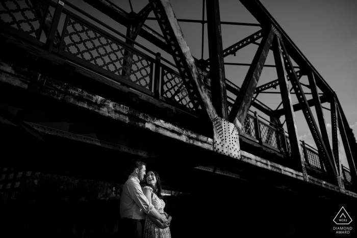 a couple celebrates their engagement with a bridge portrait session Denver, CO couple celebrates their engagement with a bridge portrait session