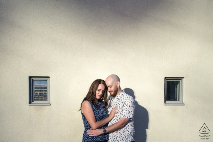 Fotografía de compromiso de Ontario de una pareja contra la pared con el sol